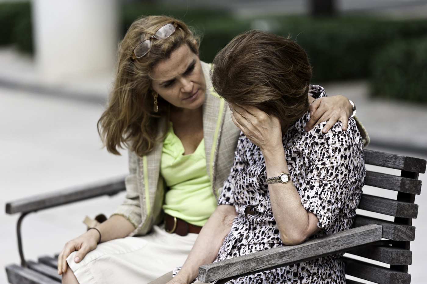 One person comforting another on a bench