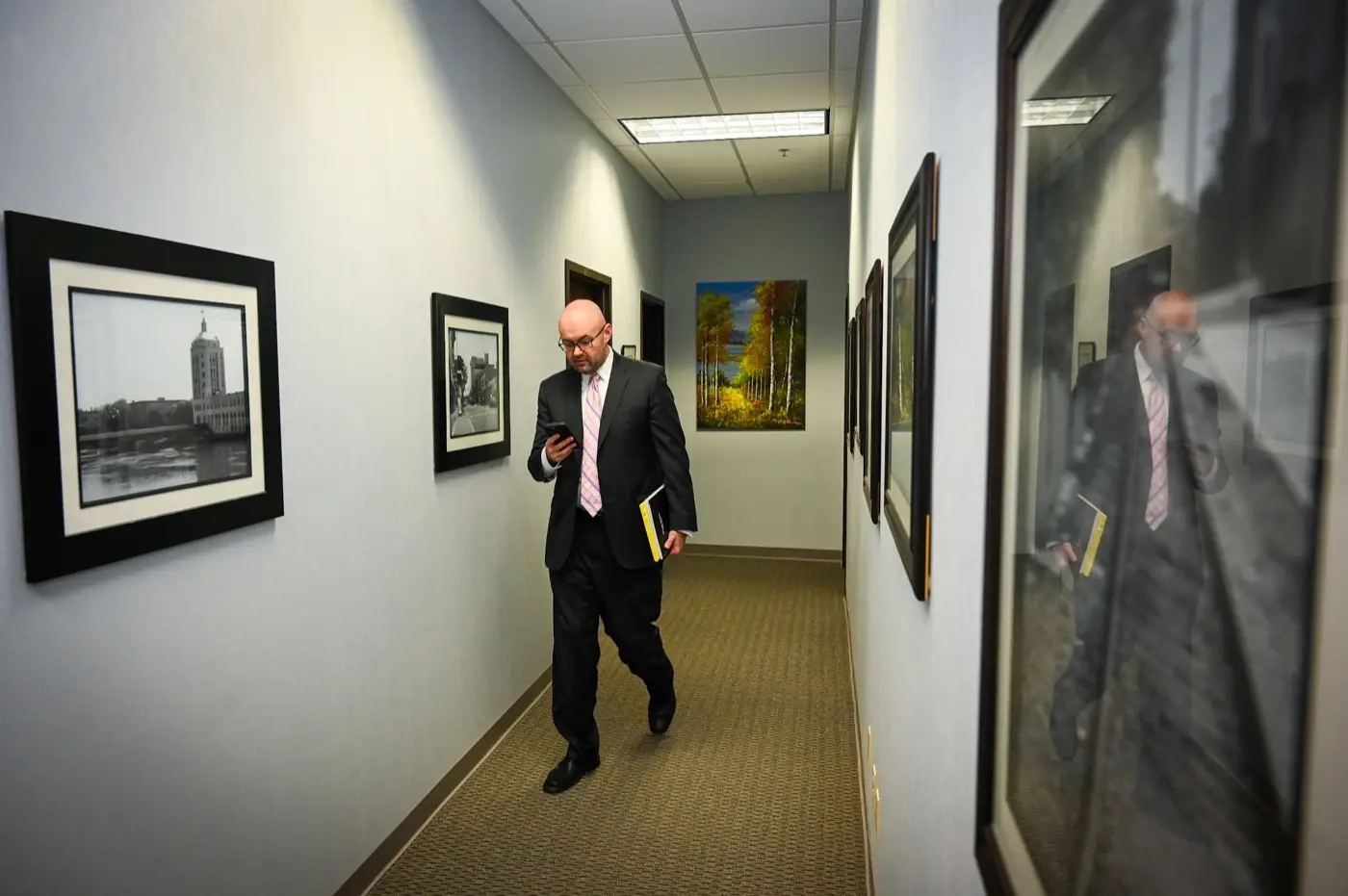 Paul M. Marriett walking through the office with a case file